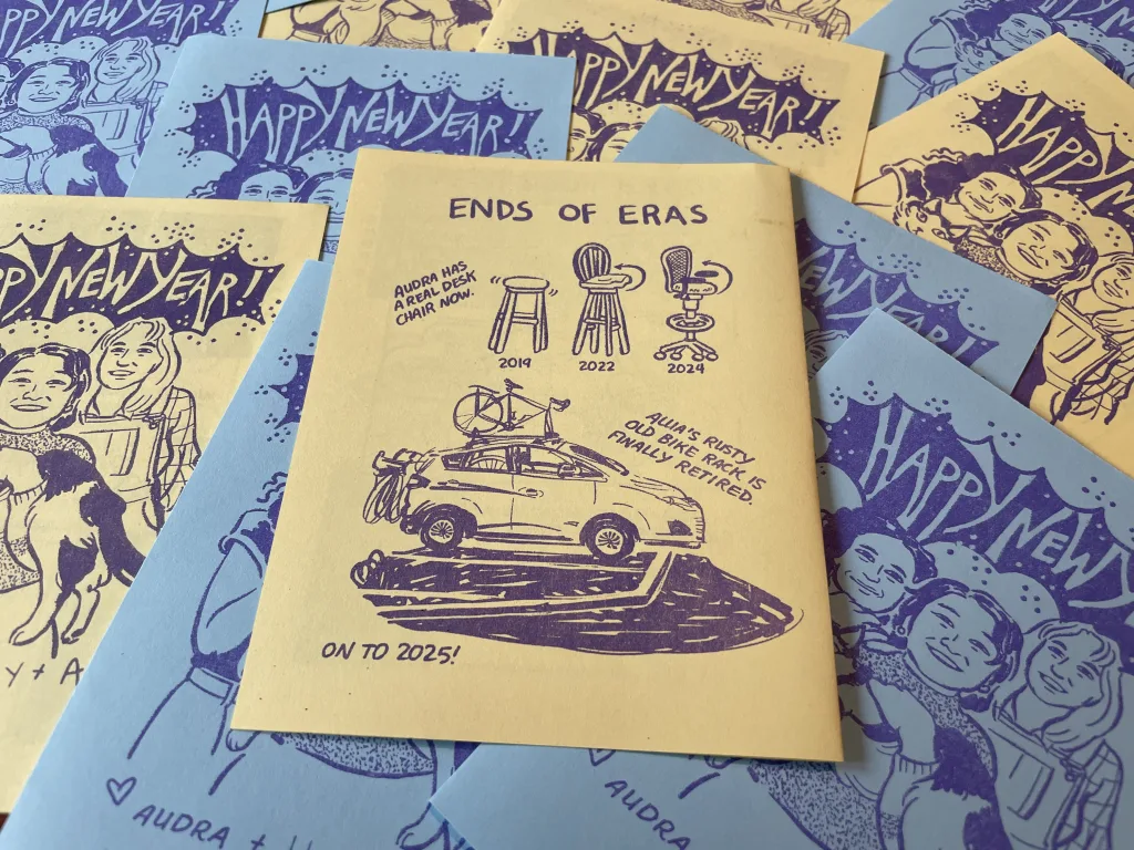 The back of a New Years card with the heading "Ends of Eras;" "Audra has a real desk chair now," "Allia's rusty bike rack is finally retired," "On to 2025!"